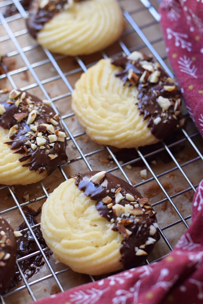 Chocolate dipped shortbread cookies on a wire rack.