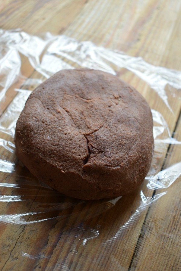 Chocolate shortbread cookie dough on plastic wrap.