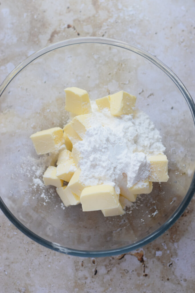 Butter and powdered sugar in a glass bowl.