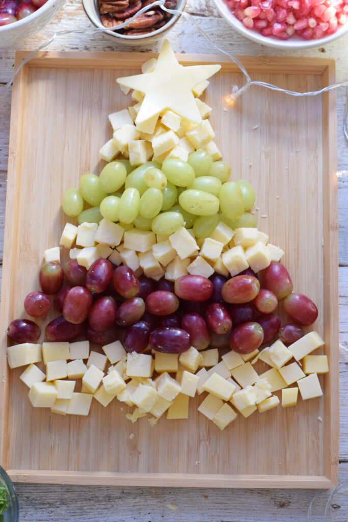 Making a Christmas tree fruit and cheese board.