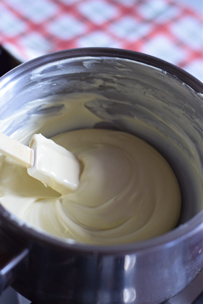 Melted white chocolate in a saucepan.