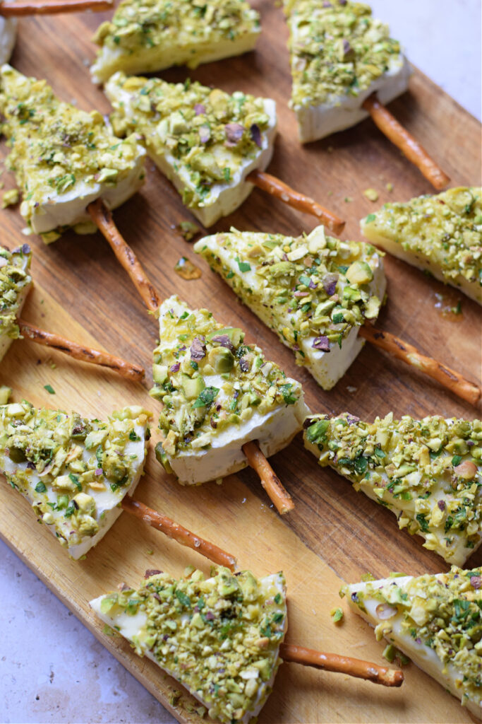 Brie cheese appetizers on a wooden board.