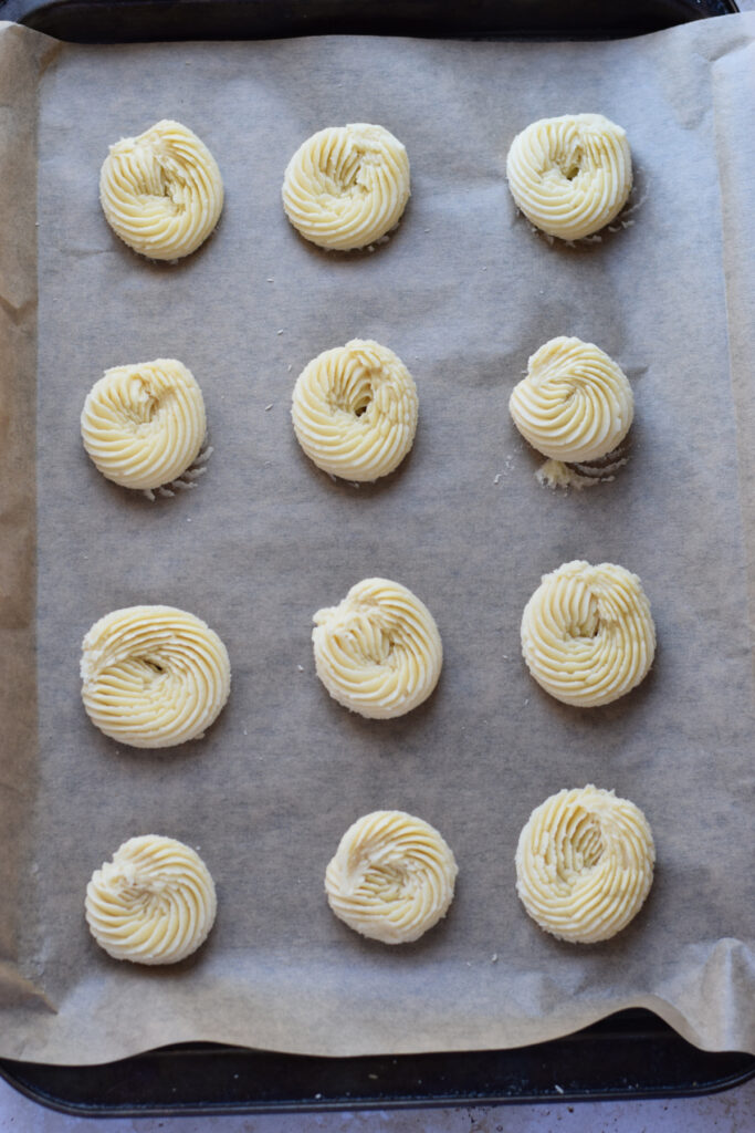 Piped cookies on a baking tray.