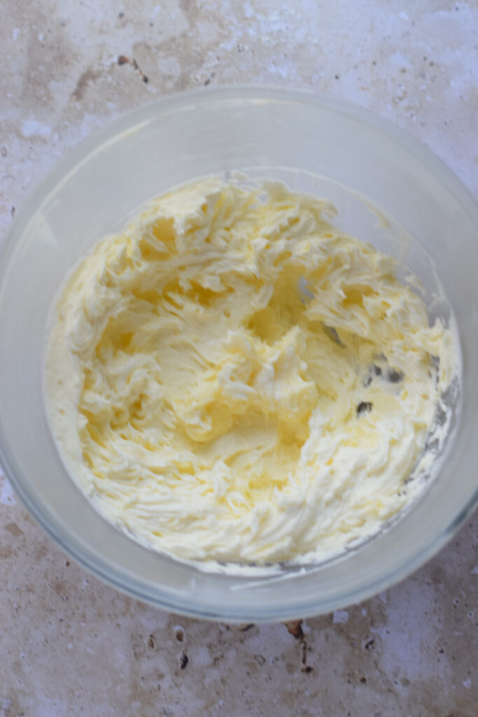 Whipped butter and sugar in a glass bowl.