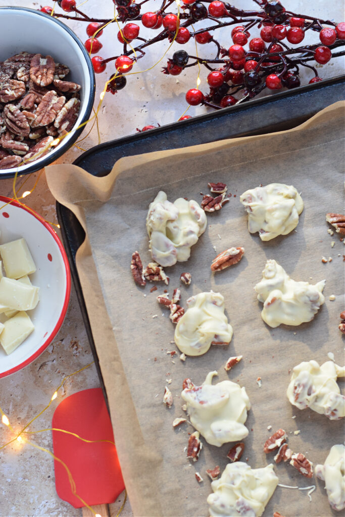 White chocolate pecan clusters on a baking tray.