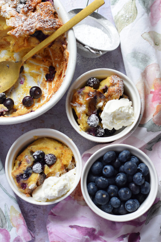 Blueberry bread pudding in white serving dishes.