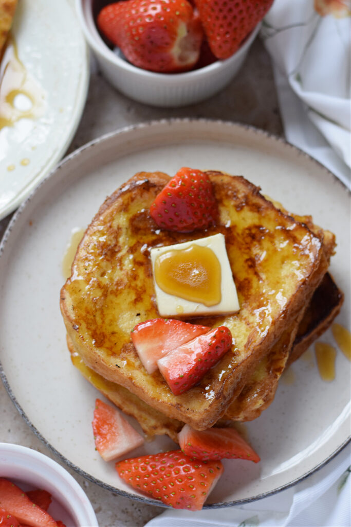 French toast on a white plate with berries.