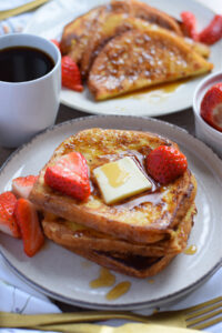 French toast with berries, maple syrup and butter.