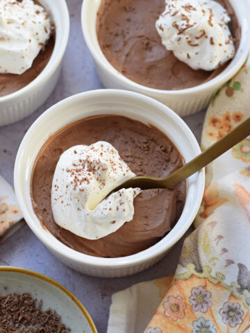 Close up of chocolate mousse in white serving dishes.