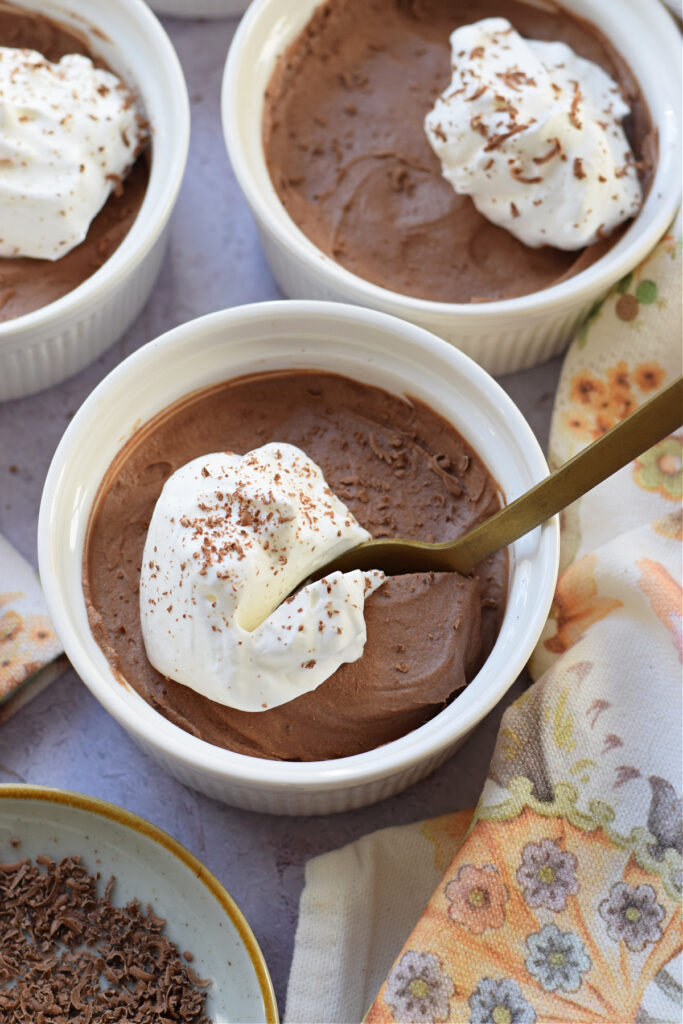 Close up of chocolate mousse in white serving dishes.