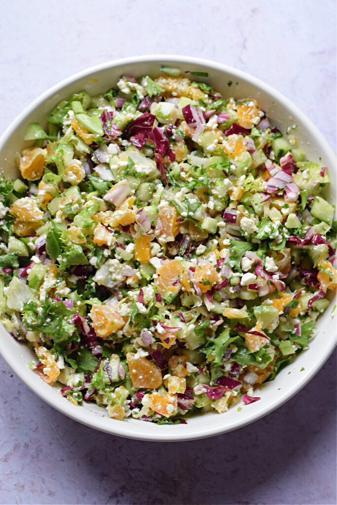 Chopped tossed salad in a white salad bowl.