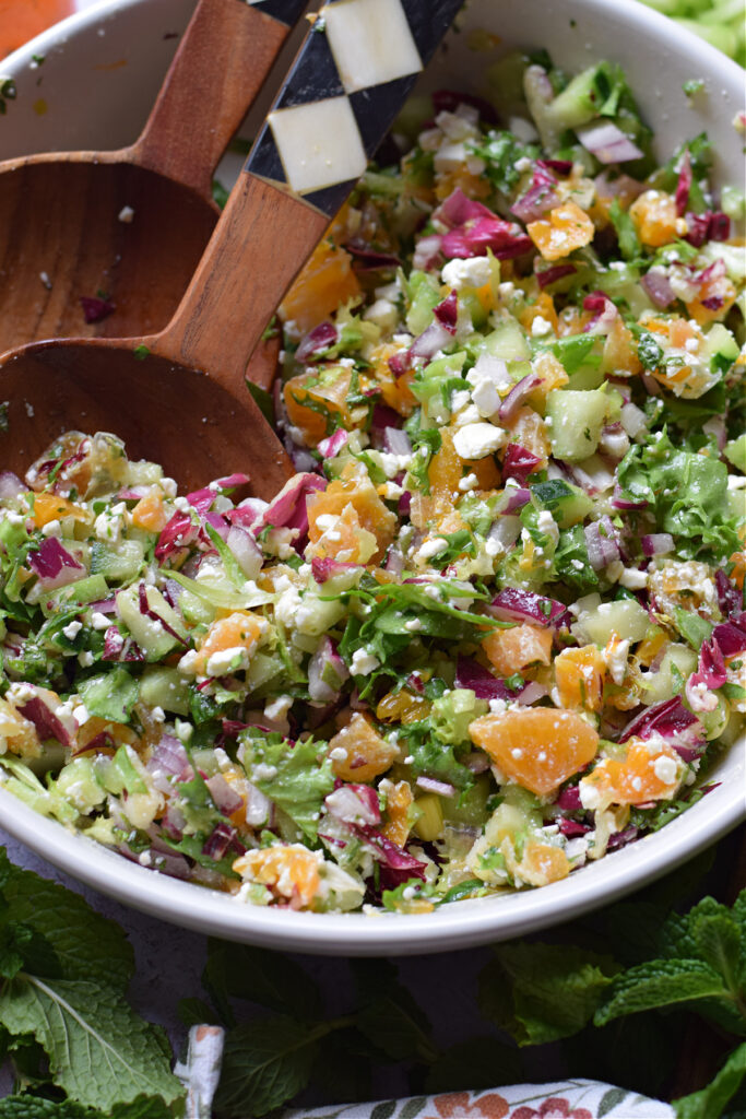 Close up of a chopped salad in a white bowl.