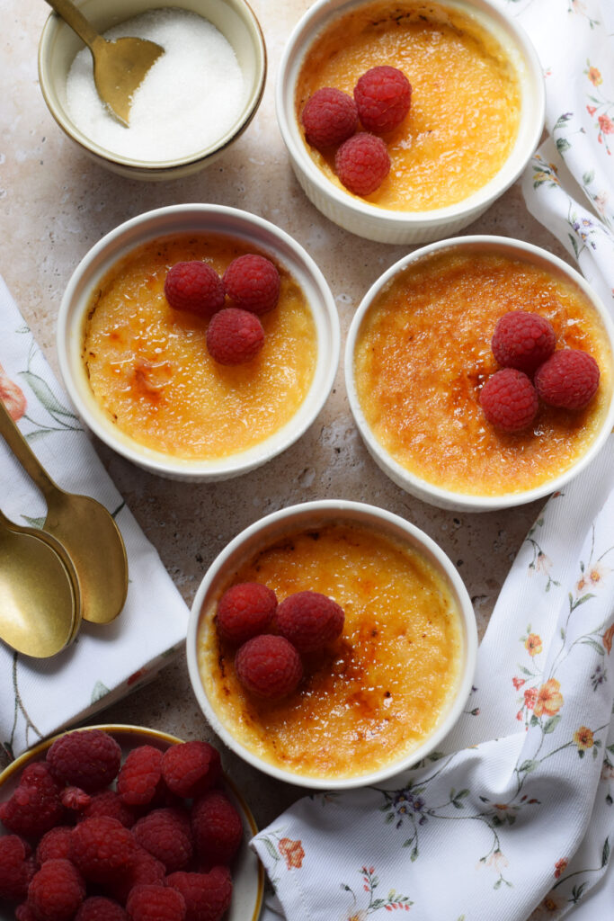 Creme brulee pots with fresh raspberries.