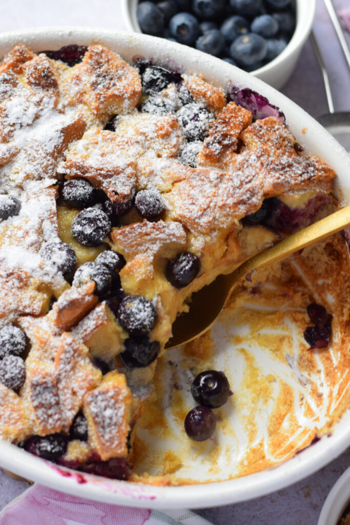 Blueberry brioche bread pudding in a white dish.