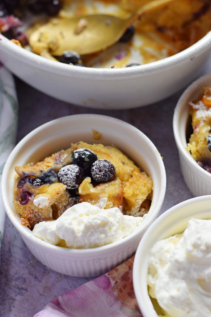 Blueberry brioche pudding in white serving dishes.