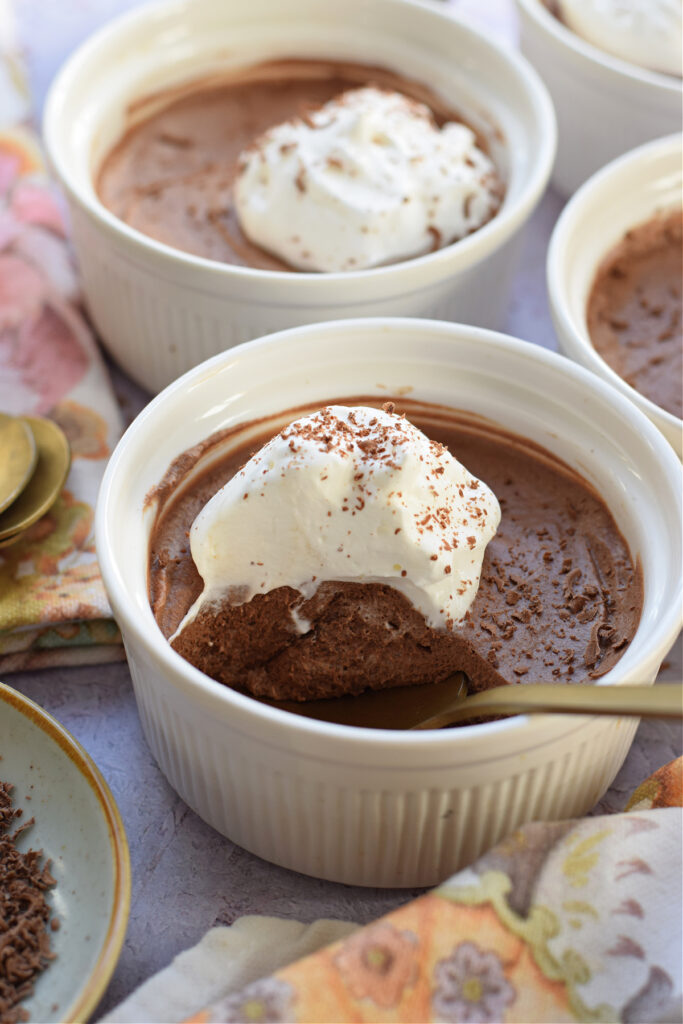 Close up of chocolate mousse in white serving dishes.