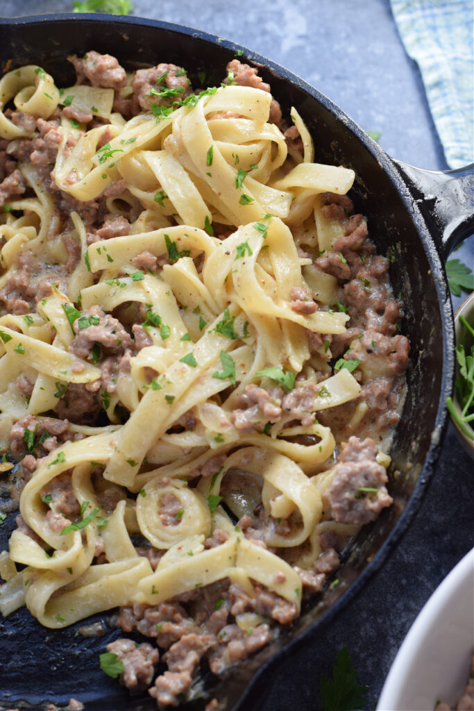 Ground beef and noodles in a skillet.