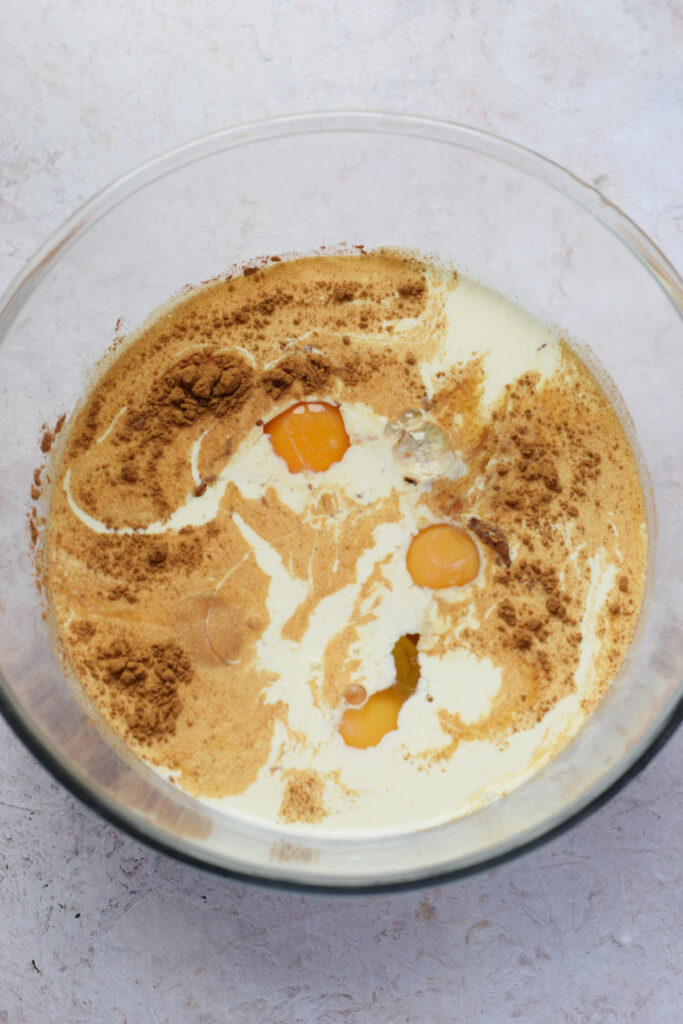 Making a bread pudding mixture in a glass bowl.