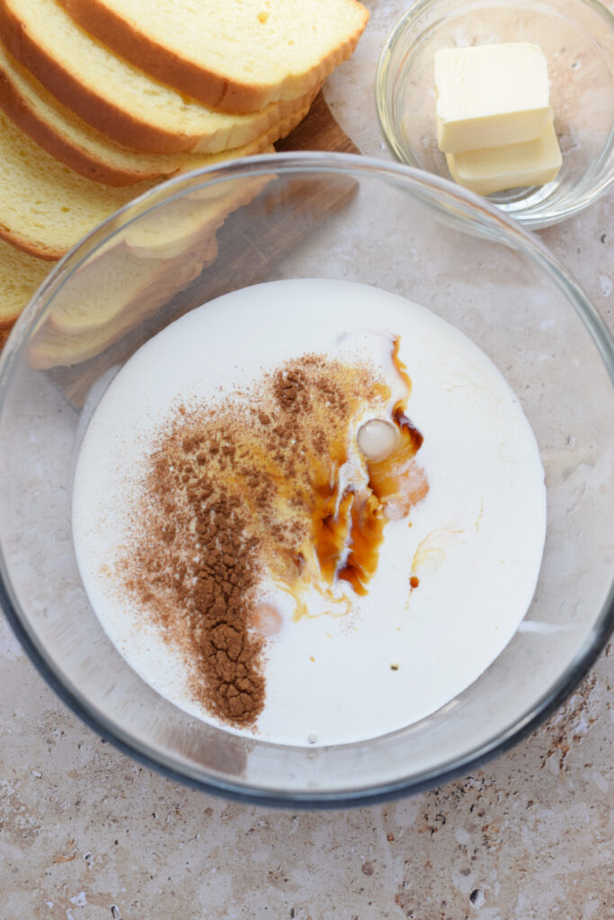 Ingredients in a glass bowl to make french toast batter.