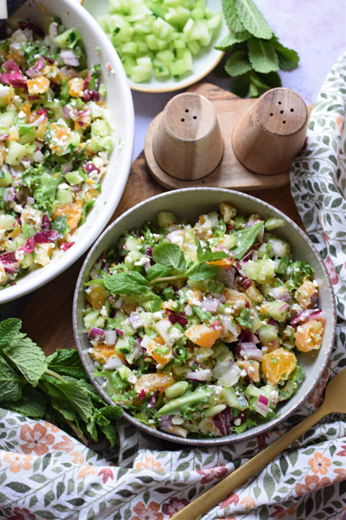 Chopped salad in a small bowl with a tea towel.