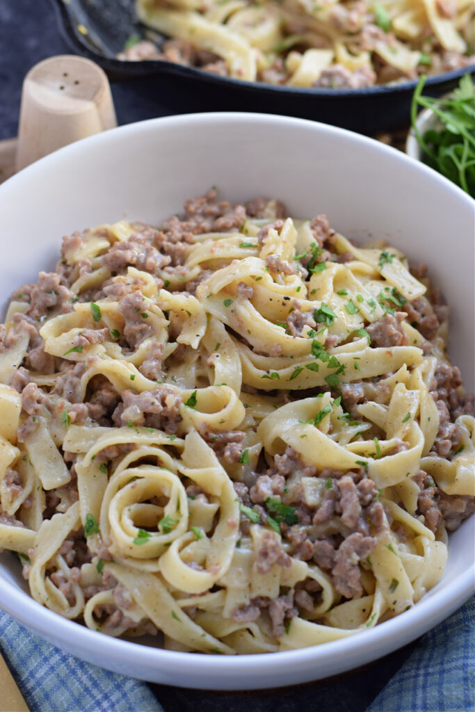 Pasta noodles and ground beef in a bowl.