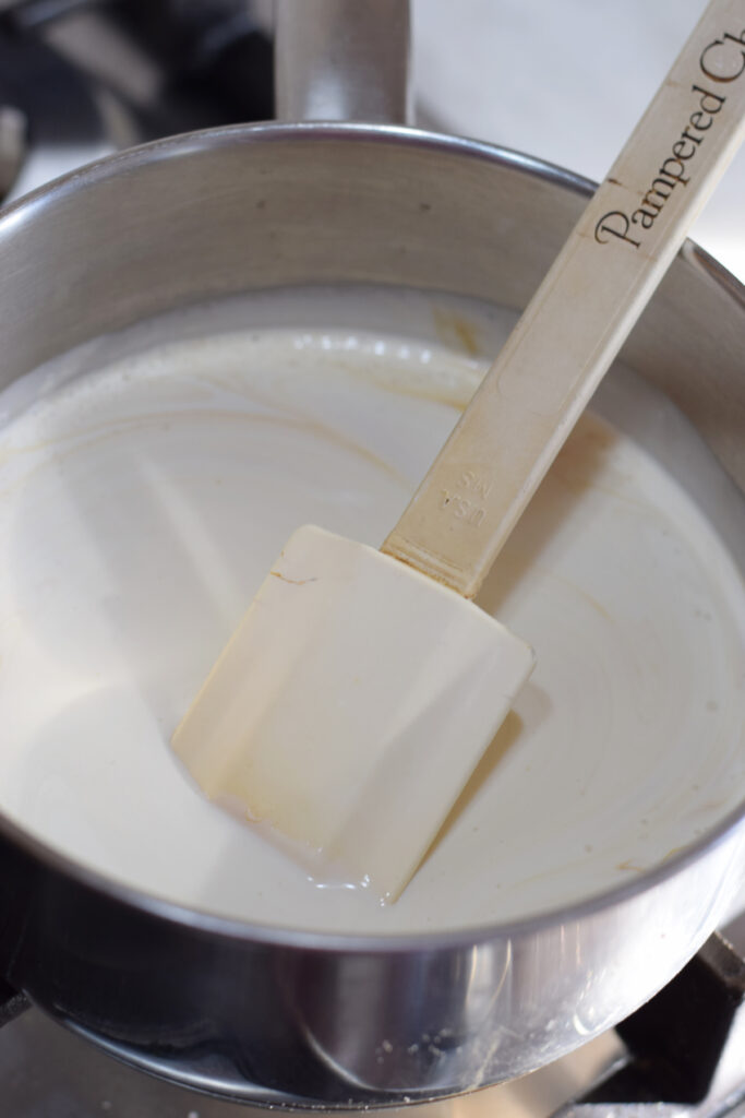 Heating cream in a saucepan.