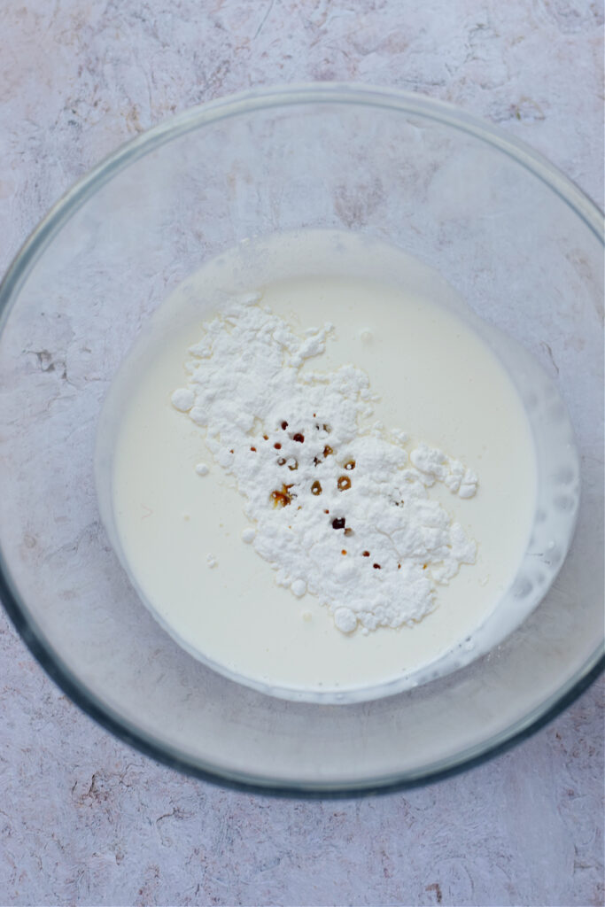 Heavy whipping cream in a glass bowl.