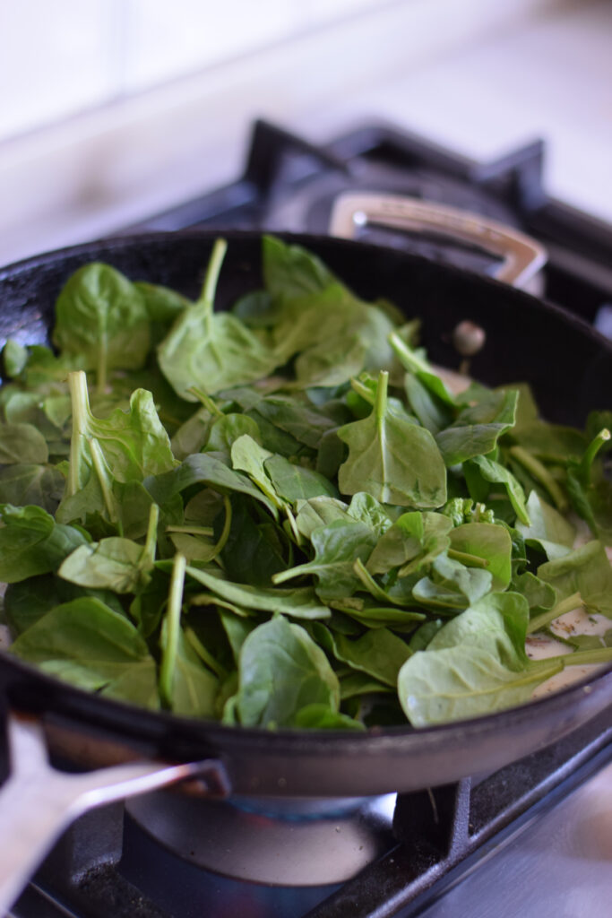 Add spinach to a skillet.