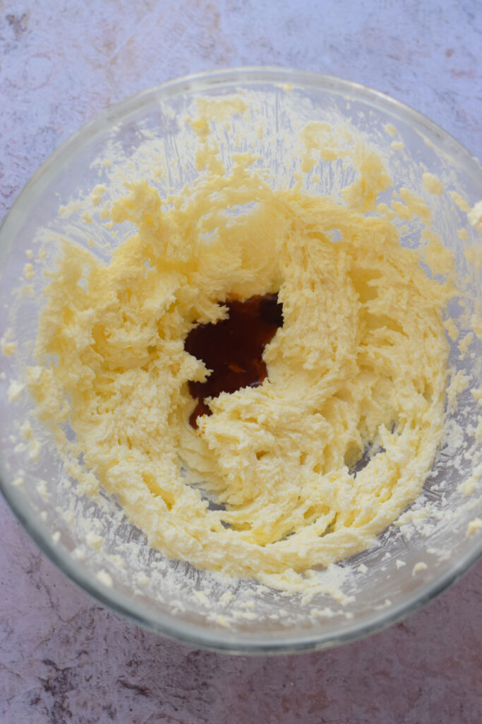 Adding eggs and vanilla extract to cake batter.