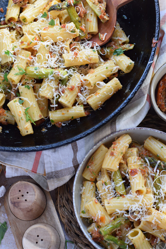 Sun dried tomato pasta in a skillet and in a bowl.