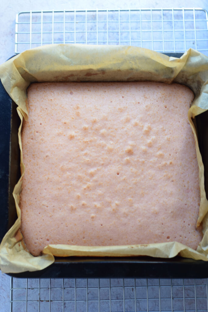 Baked pink cake in a square baking dish.