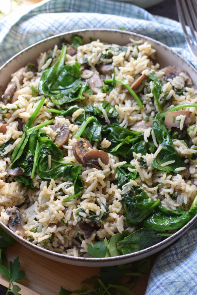 Close up of spinach mushroom rice in a bowl.