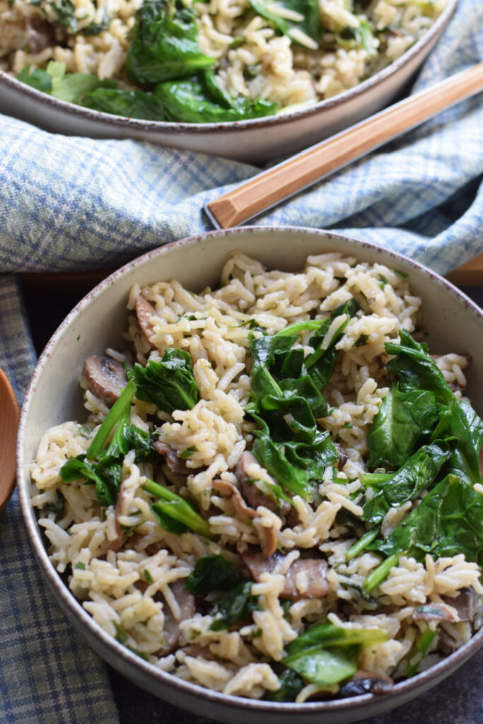 Close up of spinach mushroom rice in a bowl.