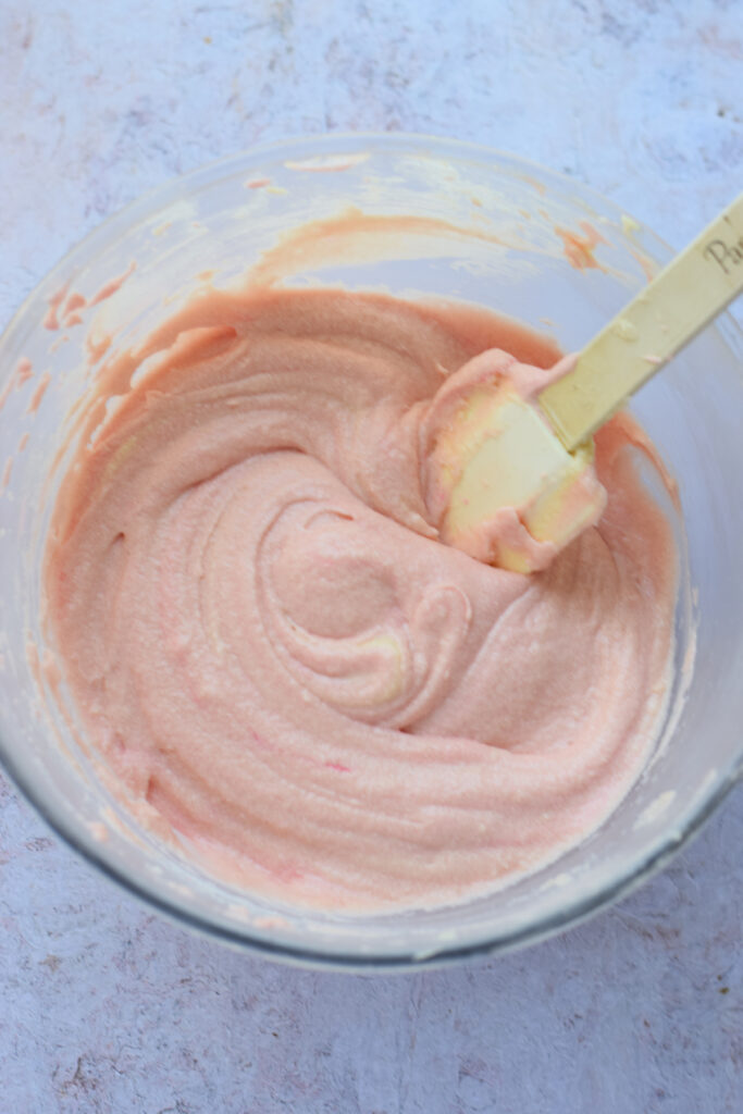 Pink cake batter in a glass bowl.