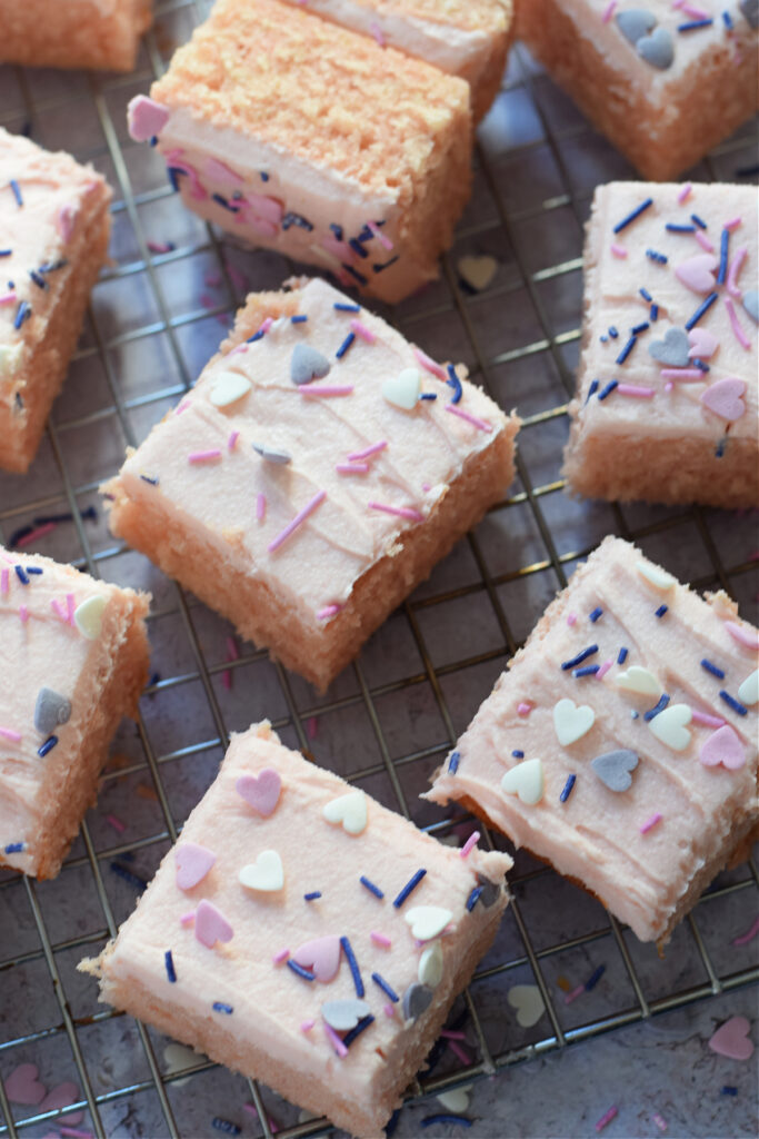 Vanilla cake squares on a cooling rack.