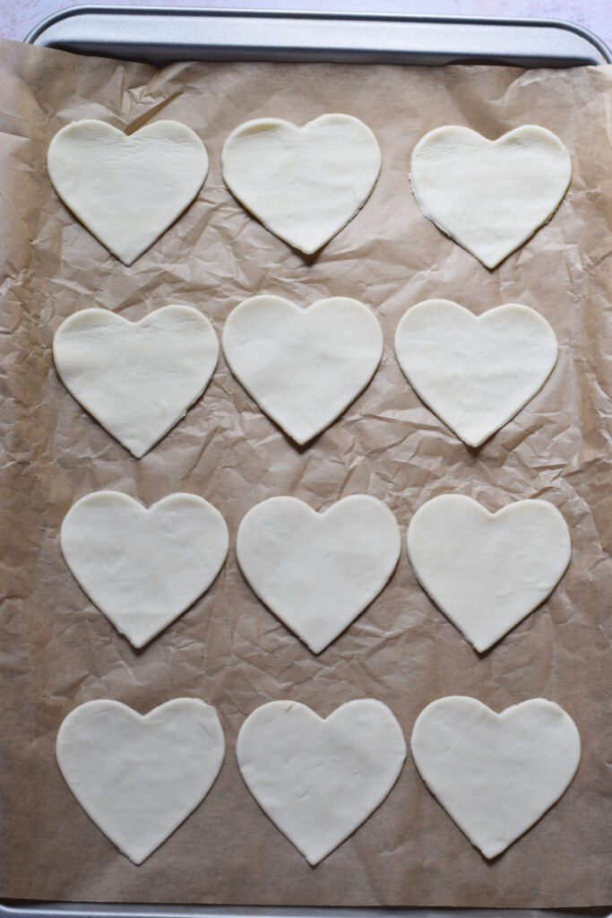 Puff pastry hearts on a baking tray.