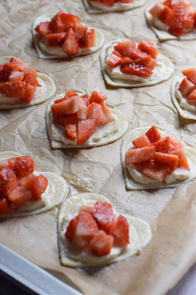 Puff pastry hearts on a baking tray ready to bake.