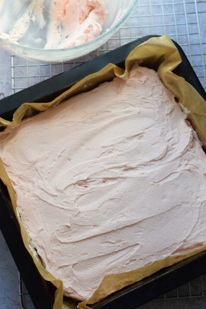 Frosted sheet pan cake in a baking pan.