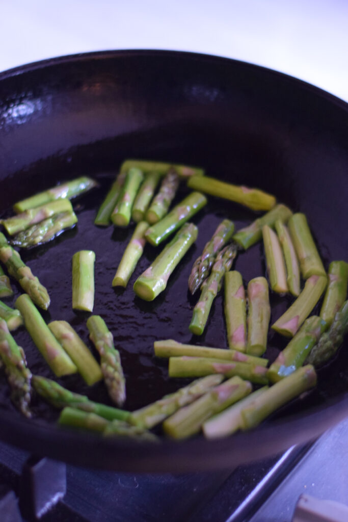 Cooking asparagus in a skillet.