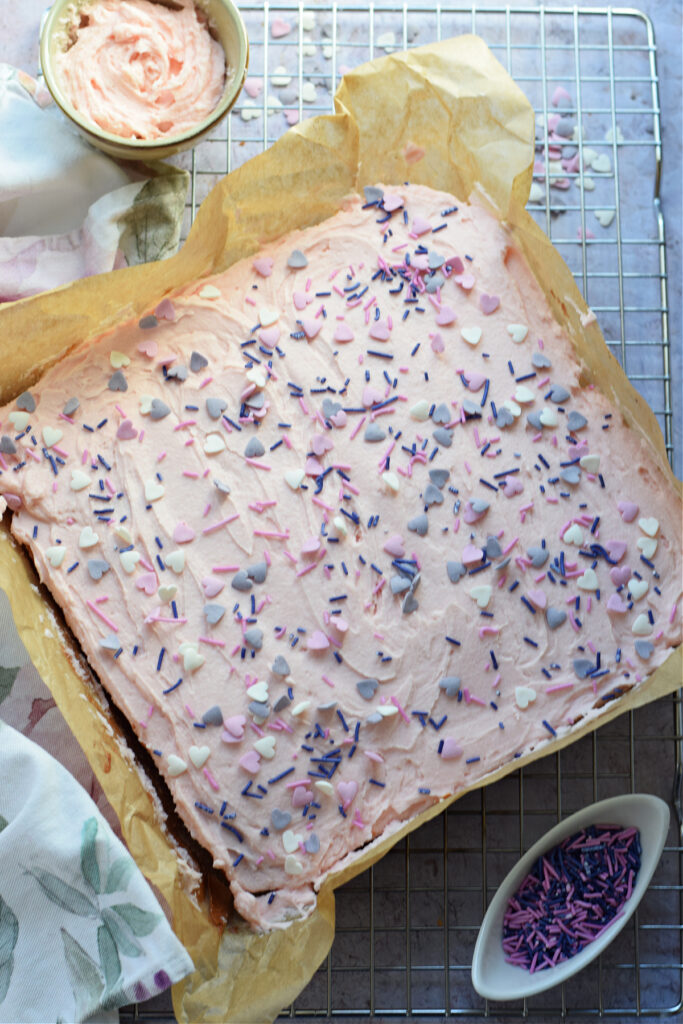 Vanilla cake with pink frosting and sprinkles.