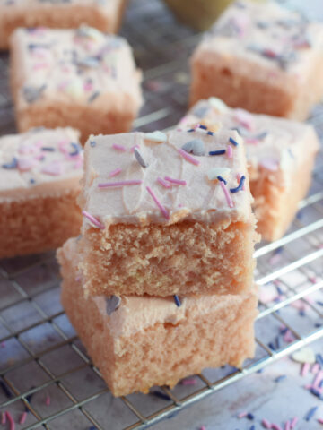 Stacked pink cake squares with valentine's day sprinkles.