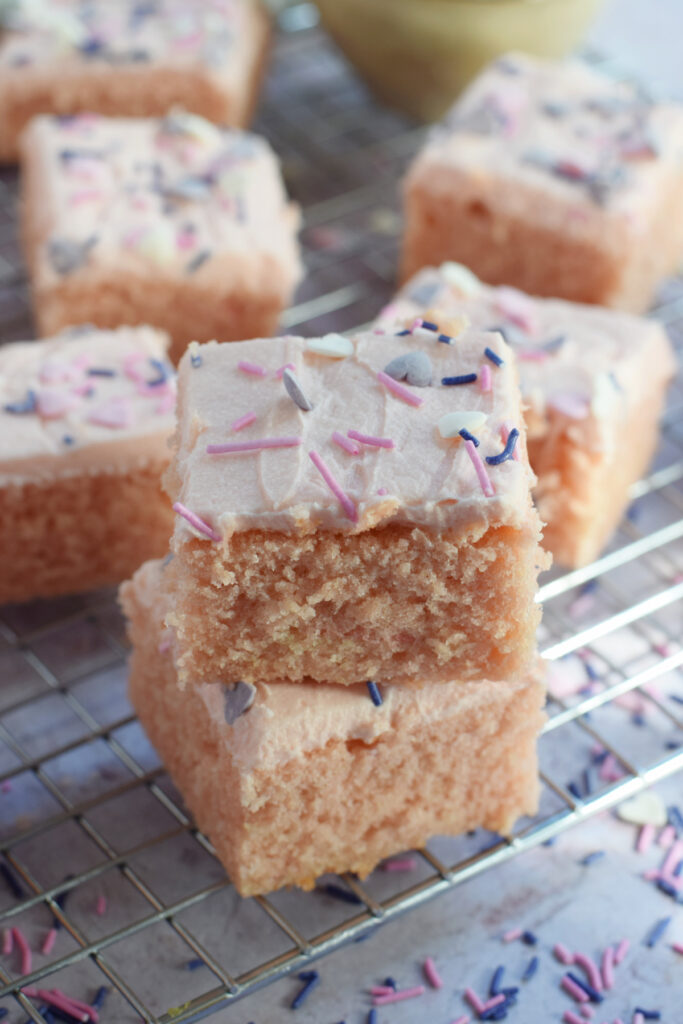 Stacked pink cake squares with valentine's day sprinkles.