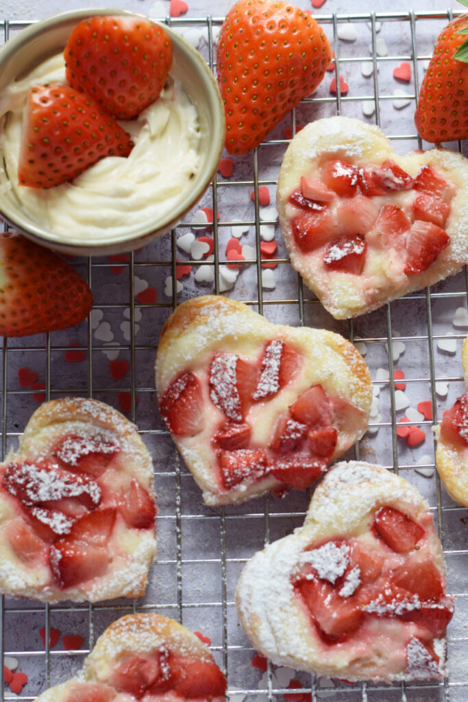 Close up of puff pastry hearts with cream cheese strawberry filling.