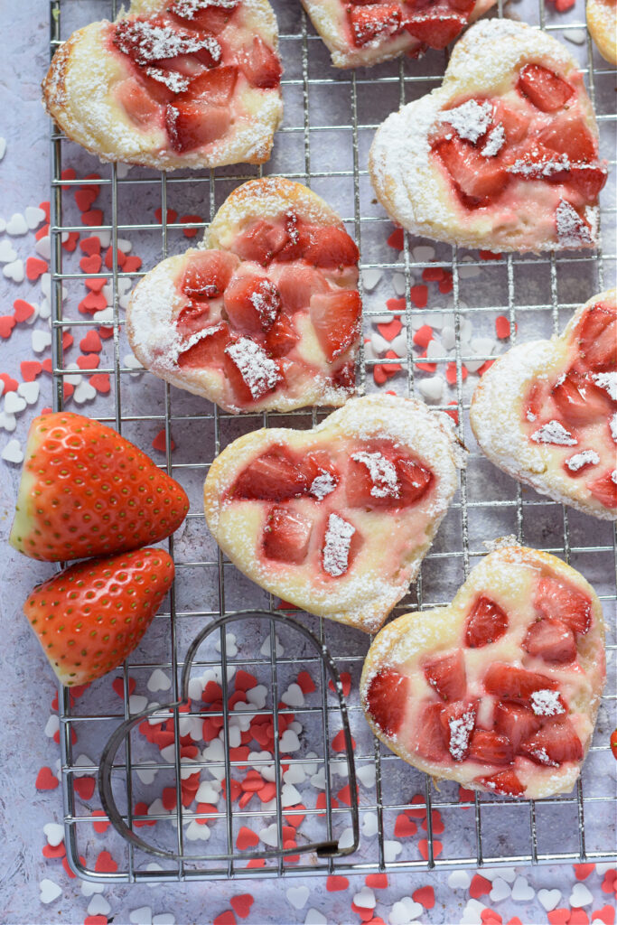 Strawberry cream cheese pastry hearts on a baking rack.