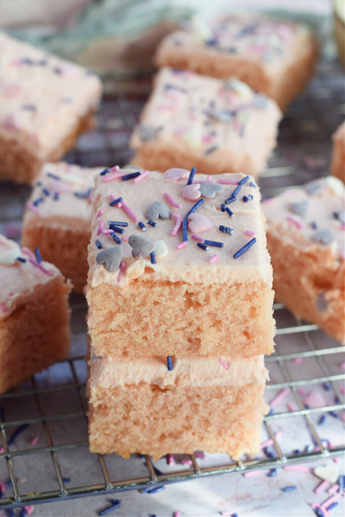 Vanilla cake squares stacked.