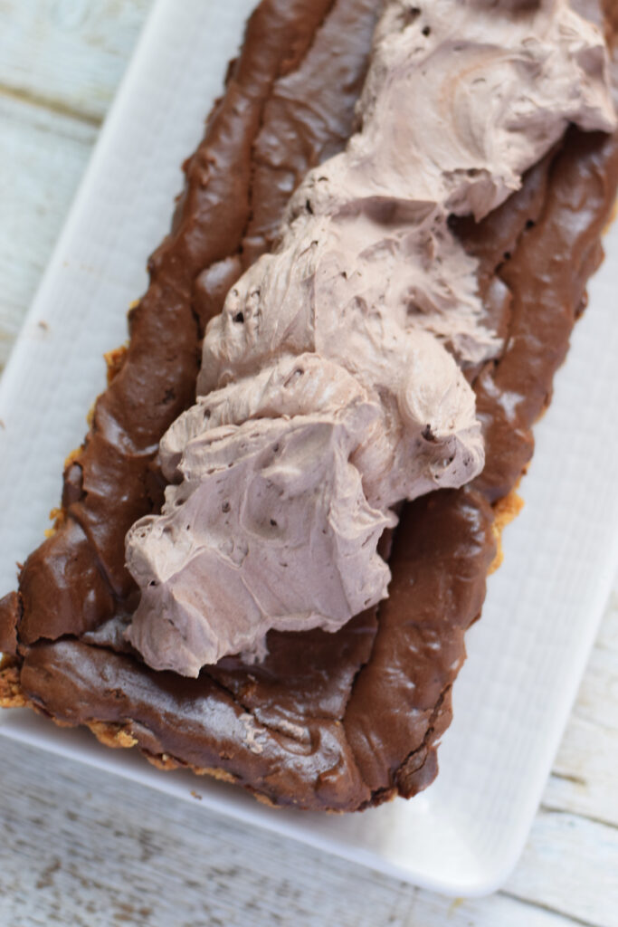 Topping a cheesecake tart with chocolate whipped cream.