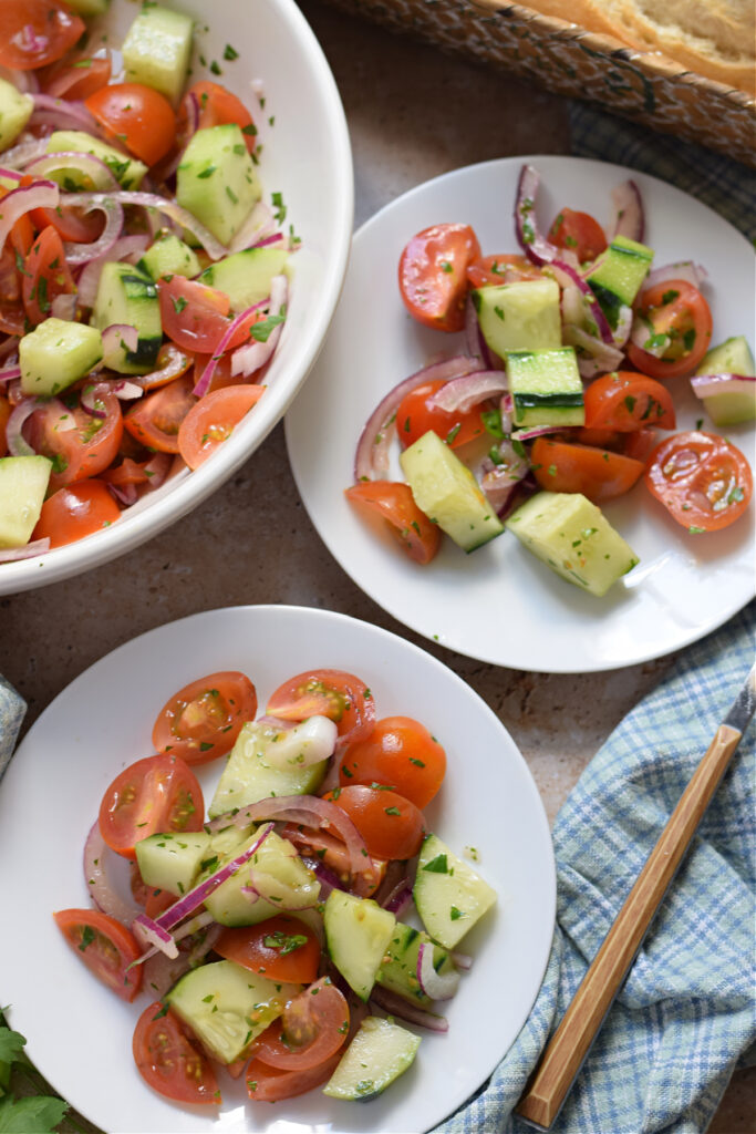 Tomato salad with cucumbers on white plates.
