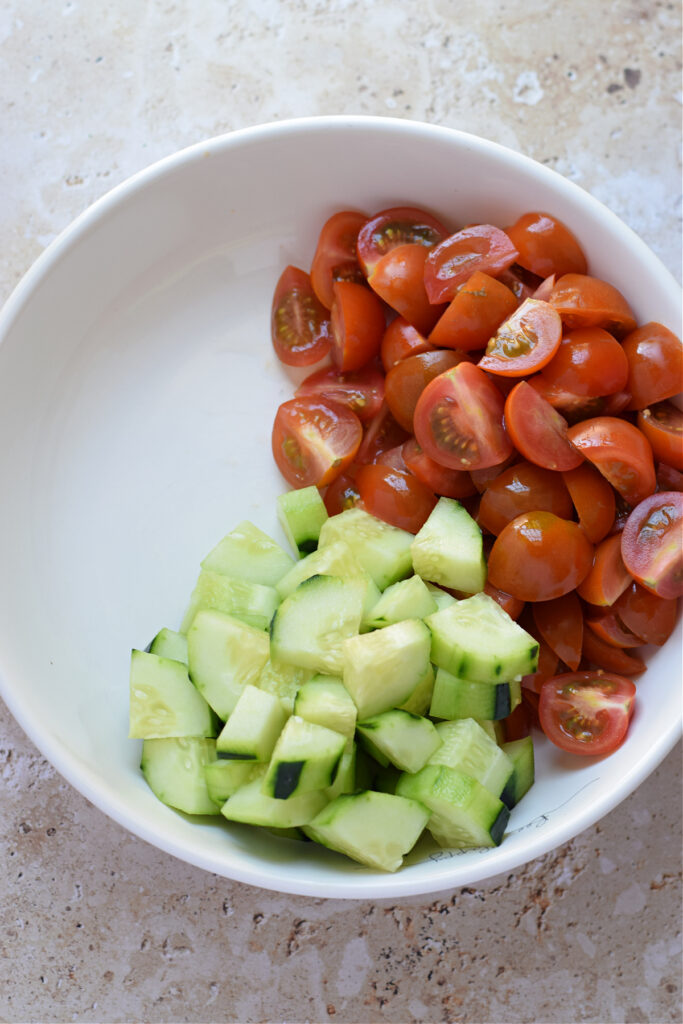 Diced cucumbers and tomatoes in a bowl.