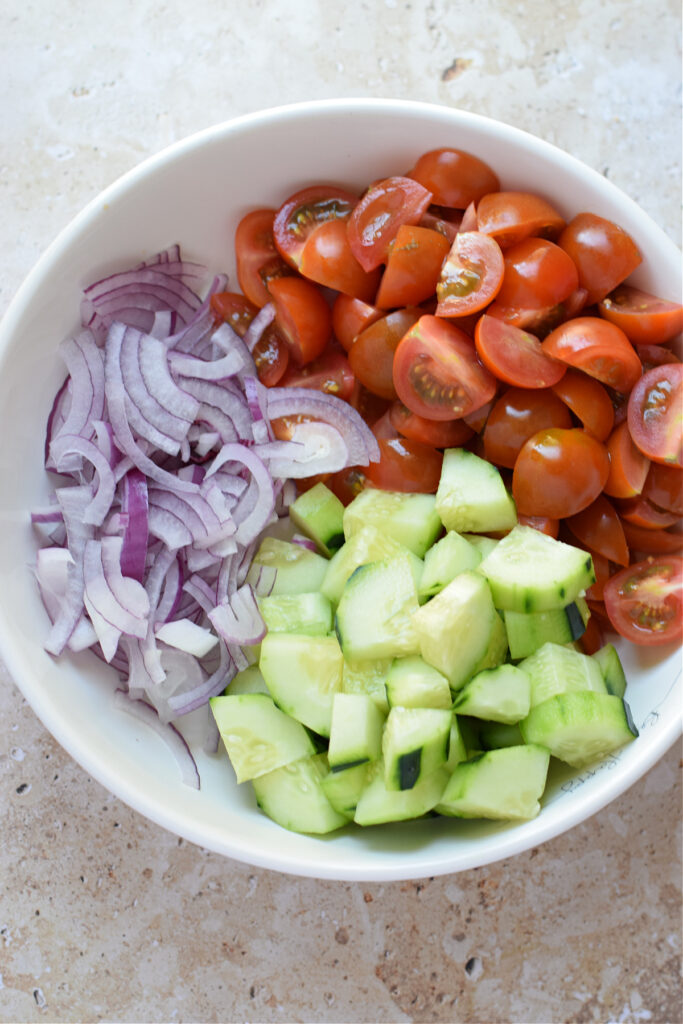 Tomatoes, cucumbers and onions in a bowl.