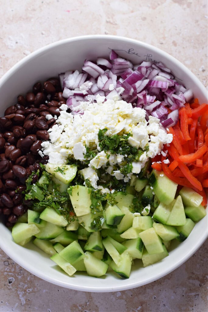 Making a salad in a white salad bowl.
